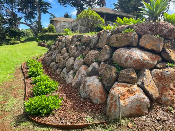 New lava-rock retaining wall and planting installed on a Maui property