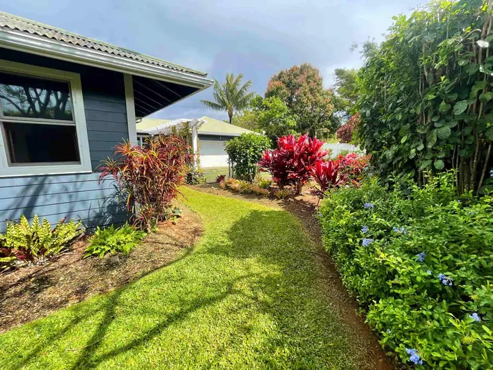 Lush, well-watered garden beds along a Maui home